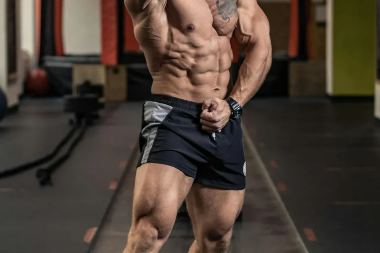 Muscular athlete flexing in studio light, illustrating the protein and muscle-building debate