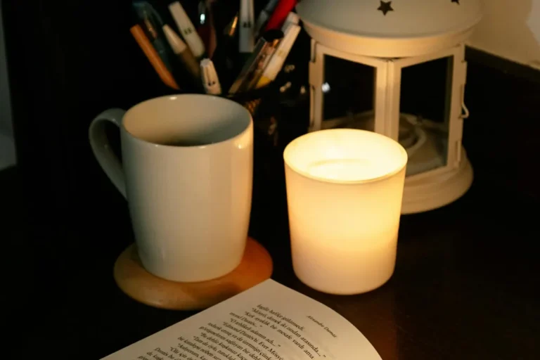 A warmly lit reading nook with an open book and a glowing candle, suggesting focus and memory