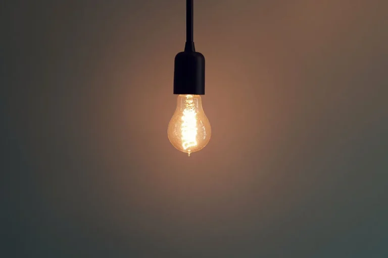 A single warm light bulb hanging in a dark room, the timeless visual shorthand for a new idea